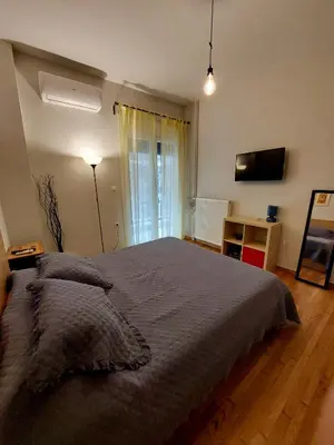 a bedroom with a large bed and a desk at Christina-Anna Athens City Center walking distance to everywhere and Acropolis, in One of the most Favorable Locations by National Gardens and Zoo, Hellenic Parliament in Syntagma and Stylish Exquisite Kolonaki Cozy Renovated Apartment in Athens