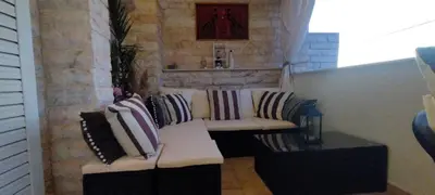 a living room with a couch with pillows on it at Villa Maria Lagonissi - Private Villa upstairs with exclusive access to pool & outside areas in Kalívia Thorikoú