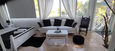 a living room with a couch and a table at Villa Maria Lagonissi - Private Villa upstairs with exclusive access to pool & outside areas in Kalívia Thorikoú