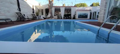 a swimming pool with blue water in a house at Villa Maria Lagonissi - Private Villa upstairs with exclusive access to pool & outside areas in Kalívia Thorikoú