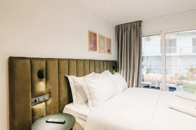a hotel room with a bed and a window at Athesense Suites in Athens