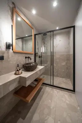 a bathroom with a sink and a glass shower at Athesense Suites in Athens