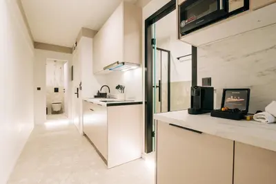 a white kitchen with a sink and a microwave at Athesense Suites in Athens