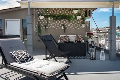 a patio with two chairs and a table on a balcony at The Athenian Oasis in Athens