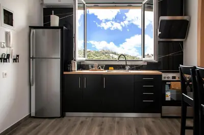 a kitchen with a sink and a large window at The Athenian Oasis in Athens