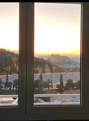 a window with a view of the city and the water at The Athenian Oasis in Athens