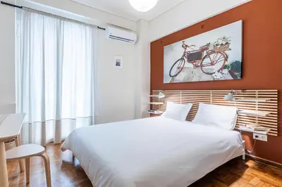 a bedroom with a bed and a bike on the wall at Laskareos Apartment by Olala Homes in Athens