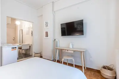 a bedroom with a bed and a desk and a tv at Laskareos Apartment by Olala Homes in Athens