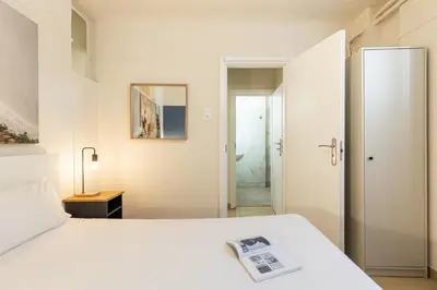 a bedroom with a white bed and a bathroom at Alexandras Apartment by Olala Homes in Athens