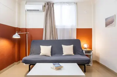 a blue couch in a room with a window at Alexandras Apartment by Olala Homes in Athens