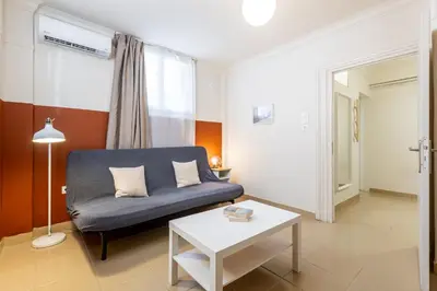 a living room with a blue couch and a table at Alexandras Apartment by Olala Homes in Athens
