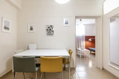 a dining room with a white table and yellow chairs at Alexandras Apartment by Olala Homes in Athens