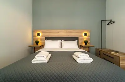 a bedroom with a large bed with towels on it at Karma Athens II in Athens