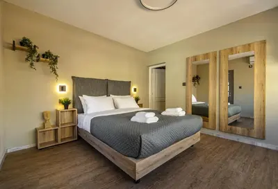 a bedroom with a large bed and a large mirror at Karma Athens II in Athens