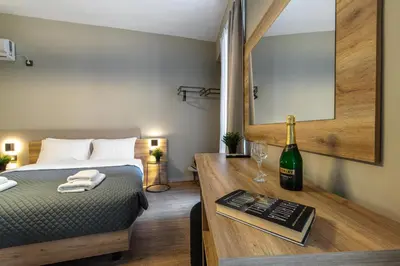 a bedroom with a bed and a bottle of wine on a desk at Karma Athens II in Athens
