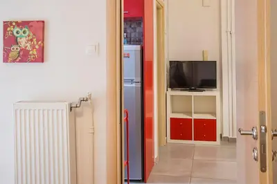a hallway with a refrigerator and a tv in a room at City stay Ambelokipi Panormou '' cozy apartment'' in Athens