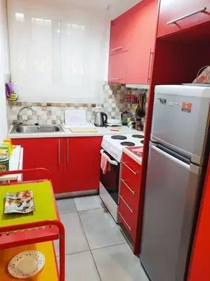 a kitchen with red cabinets and a white refrigerator at City stay Ambelokipi Panormou '' cozy apartment'' in Athens