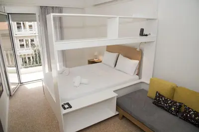 a small room with a white bunk bed and a couch at Syntagma View Apartment in Athens