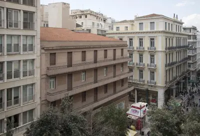 a city street with tall buildings and a bus at Syntagma View Apartment in Athens