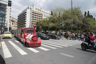 a small red train driving down a city street at Syntagma View Apartment in Athens