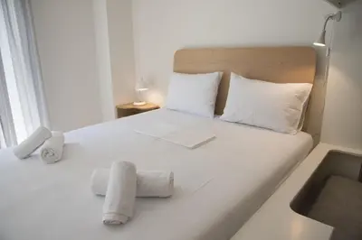 a bedroom with a white bed with towels on it at Syntagma View Apartment in Athens