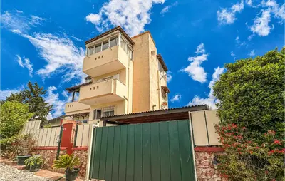 a tall building with a green garage in front of it at 3 Bedroom Cozy Home In Koropi in Koropíon