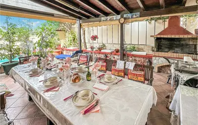 a table with plates and napkins on a patio at 3 Bedroom Cozy Home In Koropi in Koropíon