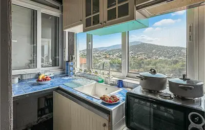 a kitchen with a sink and a view of a mountain at 3 Bedroom Cozy Home In Koropi in Koropíon