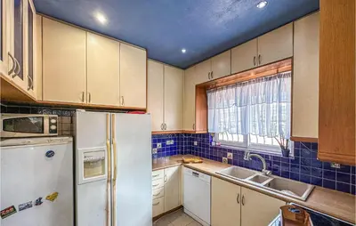 a kitchen with a refrigerator and a sink and a window at 3 Bedroom Cozy Home In Koropi in Koropíon