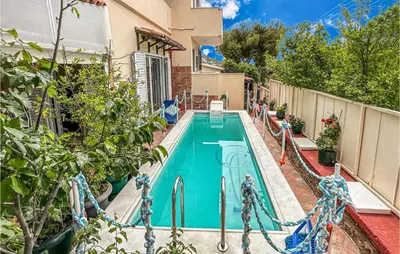 a swimming pool in the backyard of a house at 3 Bedroom Cozy Home In Koropi in Koropíon