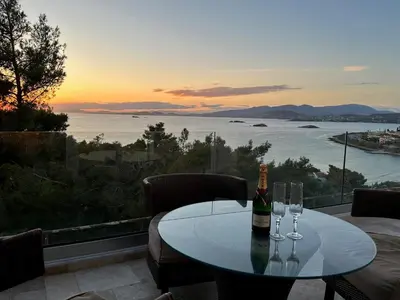 a table with two glasses and a bottle of wine at Luxurious 2-Bed Seaside Apartment in Saronida in Saronida