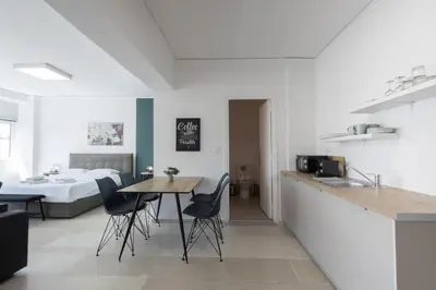 a kitchen with a table and chairs and a bed at Hip And Fun Apt B in Athens
