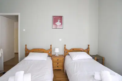 two beds sitting next to each other in a bedroom at Andromaxi 2BR Apt near SNFCC, AC, WiFi in Athens