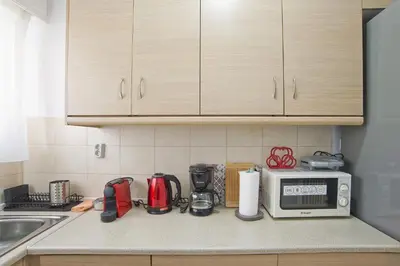 a kitchen counter with a microwave and appliances on it at Andromaxi 2BR Apt near SNFCC, AC, WiFi in Athens