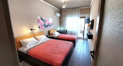 a hotel room with two beds and a television at VISTA MARE beachfront apartment. in Saronida
