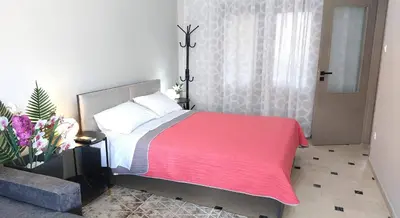 a bedroom with a bed with a red blanket at VISTA MARE beachfront apartment. in Saronida
