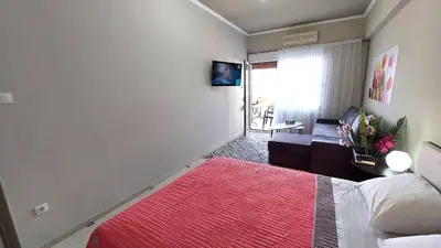 a bedroom with a bed and a living room at VISTA MARE beachfront apartment. in Saronida