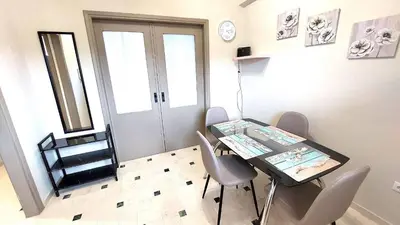 a dining room with a table and chairs and a window at VISTA MARE beachfront apartment. in Saronida