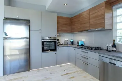 a kitchen with white appliances and wooden cabinets at Divine Home Beach Retreat in Anavissos