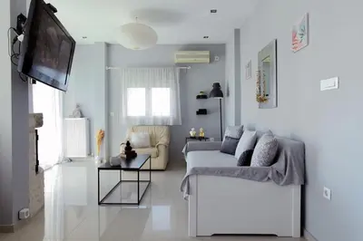 a living room with a couch and a tv at Divine Home Beach Retreat in Anavissos