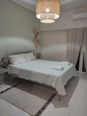a bedroom with a large bed and a chandelier at M.V Apartment in Athens