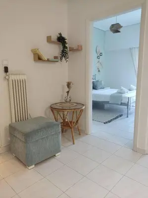 a living room with a table and a room with a bed at M.V Apartment in Athens
