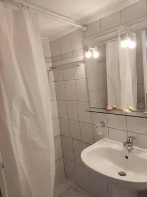 a bathroom with a sink and a shower curtain at M.V Apartment in Athens