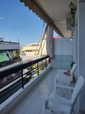 a balcony with two chairs and a table on a building at M.V Apartment in Athens