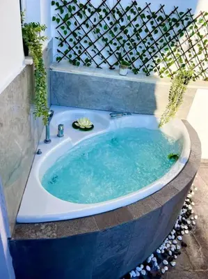 a jacuzzi tub in a garden with a fence at Athens Acropolis View in Athens