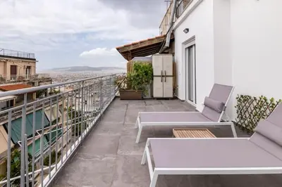 a balcony with a table and chairs on a building at Athens Acropolis View in Athens