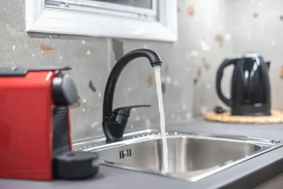 a kitchen sink with a faucet with water coming out at Ano Patisia Station Studio in Athens