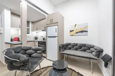 a living room with two couches and a kitchen at Ano Patisia Station Studio in Athens