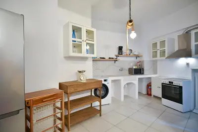 a kitchen with white cabinets and a table at Athens Stylish next to Acropolis, Metro stop Fix in Athens