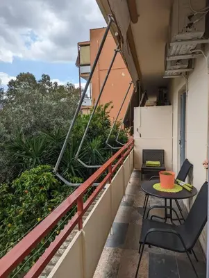 a balcony with a table and chairs on a building at Cozy apartm.near Metro Ag.Marina in Athens